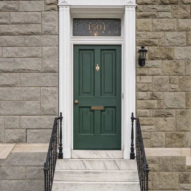 White marble steps and a painted wooden door on a Baltimore formstone rowhouse.